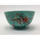 A Chinese porcelain rice bowl, the body hand painted with floral foliage on a turquoise ground,