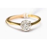 A diamond solitaire and yellow metal ring, probably 18ct gold,