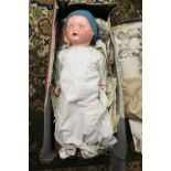 A 1930s German bisque headed doll, with painted features, glass eyes, composite body,