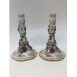 Pair of 19th Century porcelain candlesticks with out swept foot, flower and vine raised decoration,