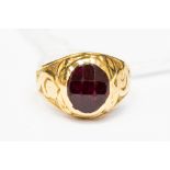 A high carat gold and red stone ring, heavy engraved detail to the shoulders,