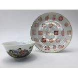 A Chinese saucer dish painted iron red with character mark medallions and gilt rim, diameter 23cm,