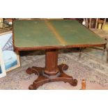 An early 19th Century rosewood fold-over card table, the top raised on an octagonal column,