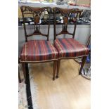 Four Edwardian carved rosewood and inlaid dining chairs