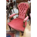 A Victorian walnut gentlemans armchair, deep buttoned back, turned arm supports and turned legs,