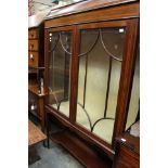 An Edwardian mahogany and inlaid display cabinet, fitted with two glazed doors enclosing shelves,