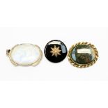 A Victorian mourning brooch, black onyx with yellow metal star set with seed pearl verso,