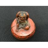 A Japanese Meiji period carved and lacquered boxwood netsuke of Raijin the Thunder God seated on