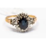 A sapphire and diamond oval cluster ring, oval sapphire approx 7mm x 6mm, in 9ct gold, size R,