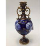 A Royal Doulton 'Chrysanthemum' pattern, twin handled bulbous footed vase on cobalt ground,