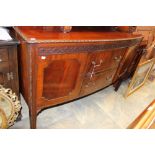 An early 20th Century mahogany sideboard, of bow-fronted form, having a blind fretwork frieze,