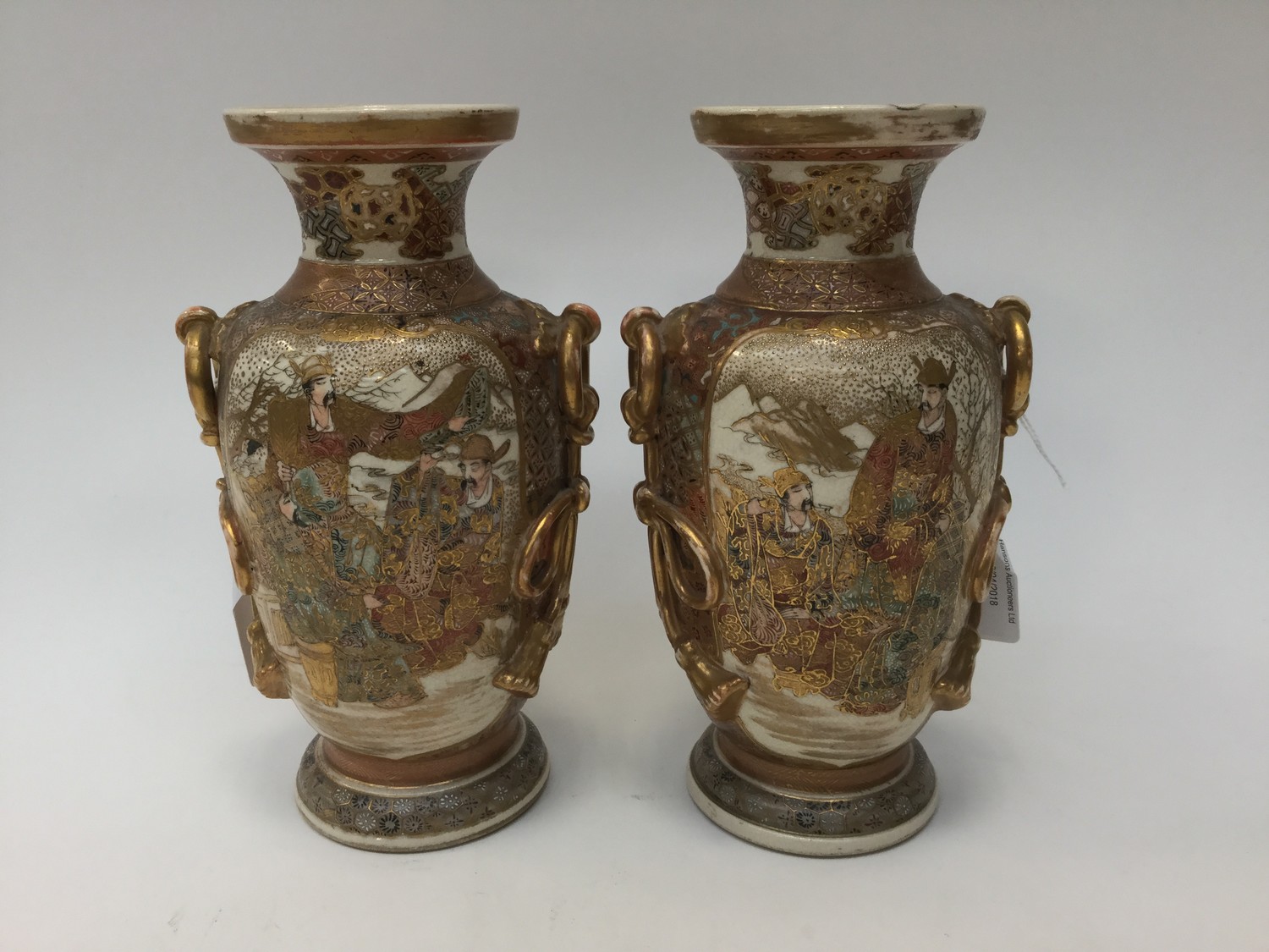 A pair of Japanese Meji period Satsuma ware vases, gilt moulded ring and knotted rope handles,