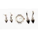 A silver ladies watch (no strap) with two pairs of white metal earrings,