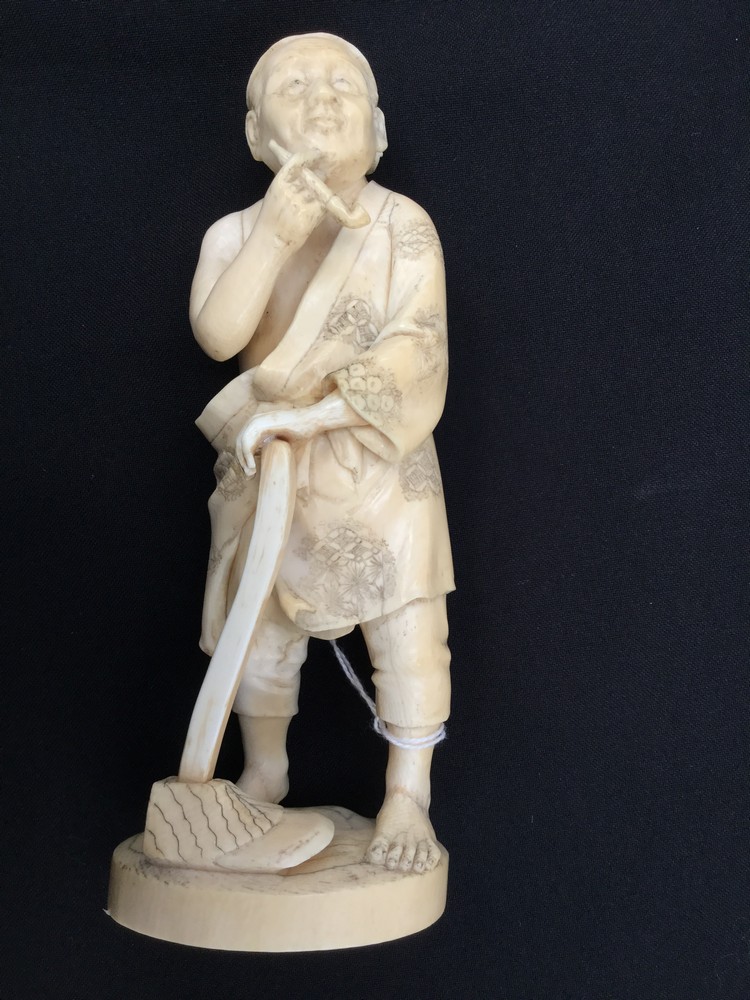 A Japanese ivory okimono of a farmer smoking a pipe, Meiji period 1868-1912,