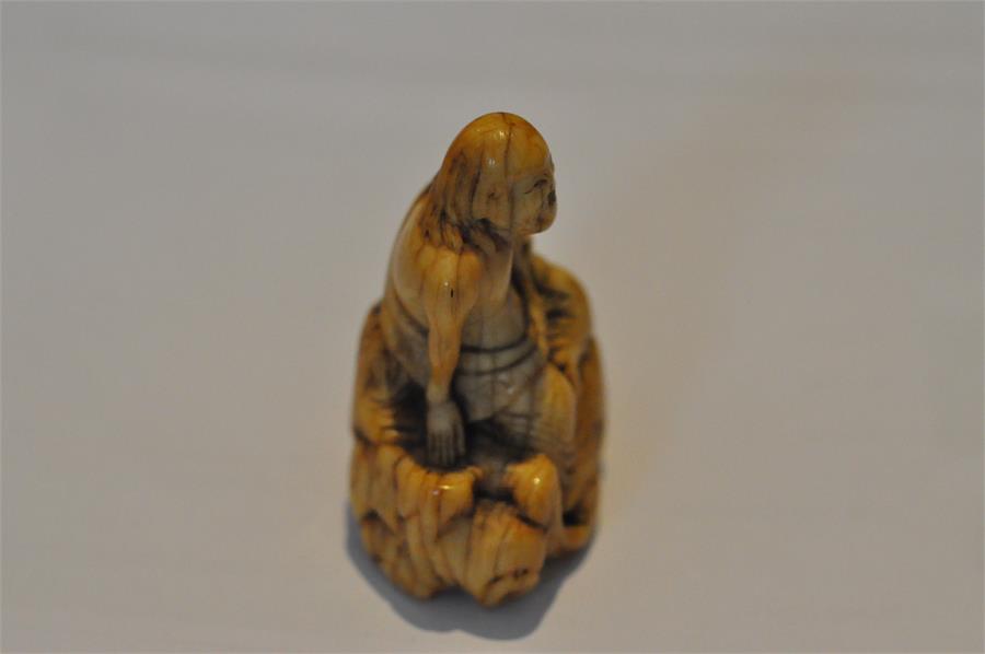 An early Japanese Edo period carved ivory netsuke, of a smiling and seated long haired man. Height 5 - Image 10 of 15