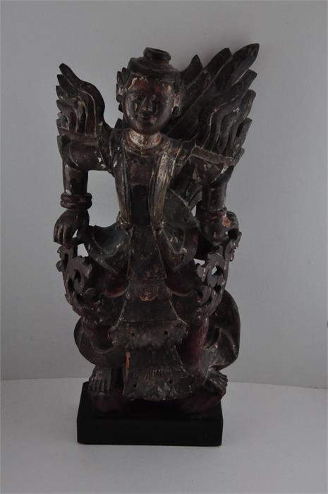 A Thai carved wood figure, early 19th century, having remains of polychrome decoration, raised