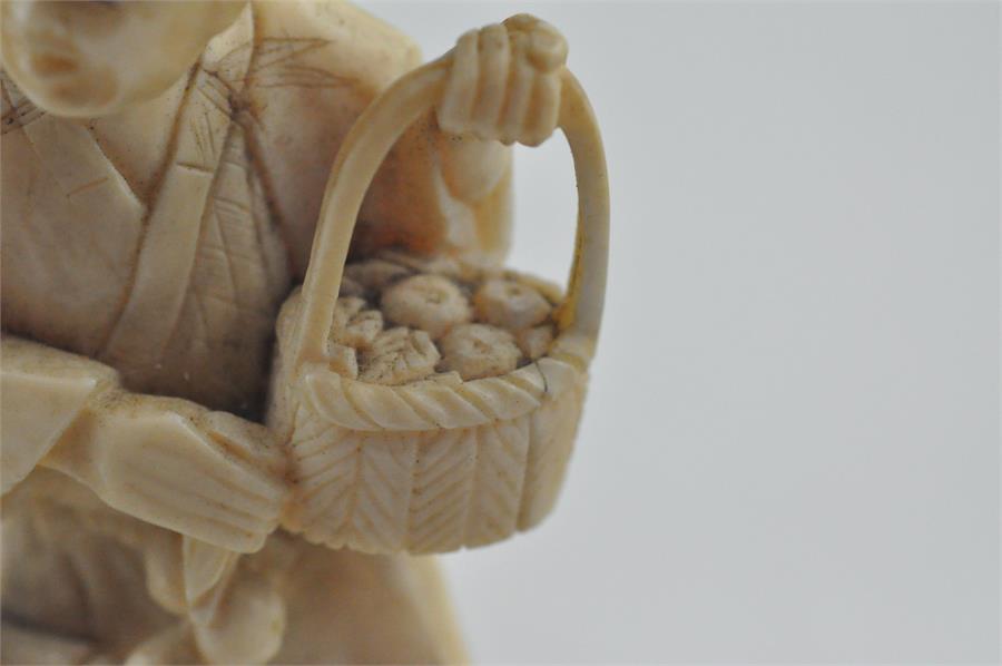 A Japanese Meiji period carved ivory okimono, of a man carrying a basket of fruit with children to - Image 5 of 6