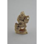 A Japanese Meiji period carved ivory okimono, of a man carrying a basket of fruit with children to