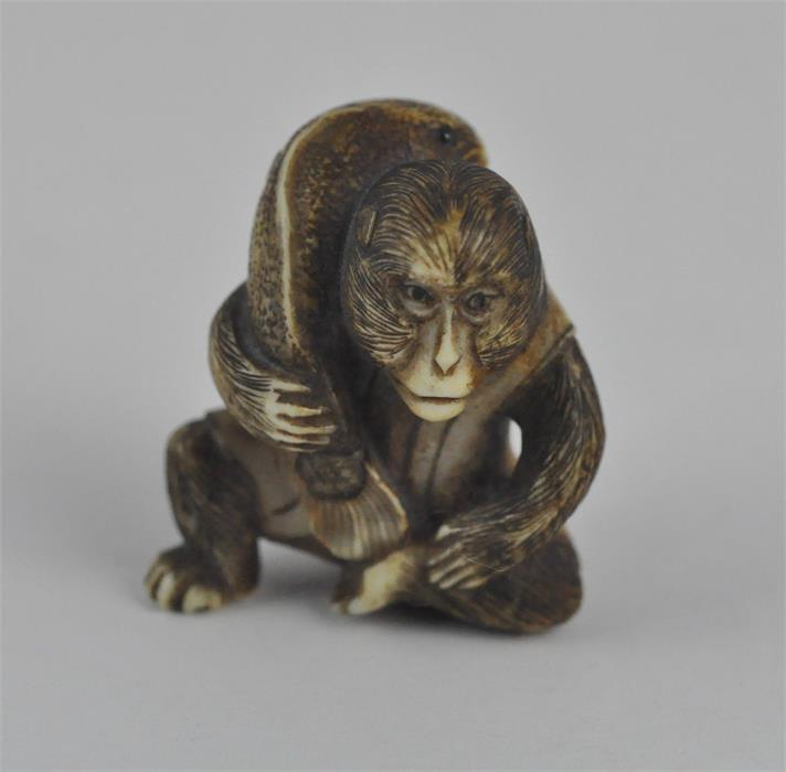 A fine Japanese Meiji period carved ivory netsuke, late 19th century, of a seated monkey wearing