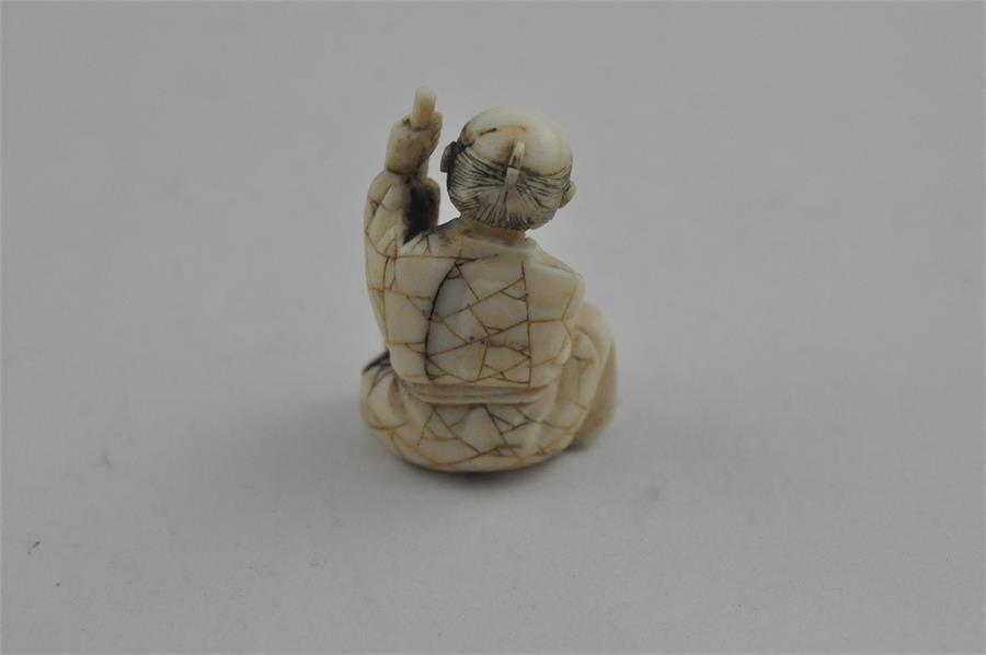 A Japanese late Meiji period carved ivory small okimono, of a man seated by log with a brush. Height - Image 3 of 5