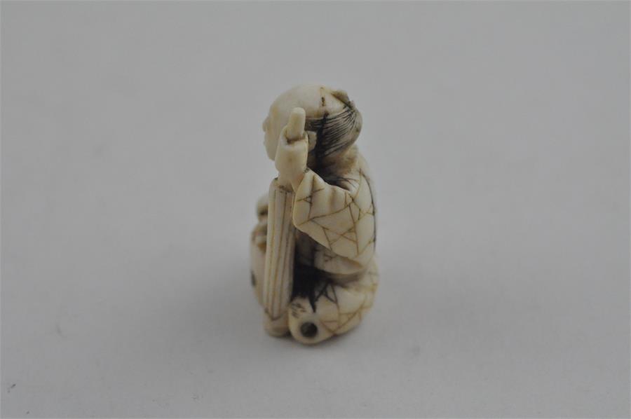 A Japanese late Meiji period carved ivory small okimono, of a man seated by log with a brush. Height - Image 2 of 5