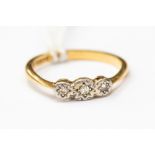 A three stone diamond ring illusion set in 18ct gold stamped, size K,