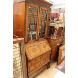 An early 20th Century oak bureau bookcase, the two glazed doors with hand carved cornice and sides,