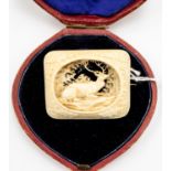 A late Victorian carved ivory rectangular brooch depicting stag within oval reserve in box