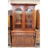 A Victorian mahogany two-tier bookcase, the upper section with an overhanging cornice,