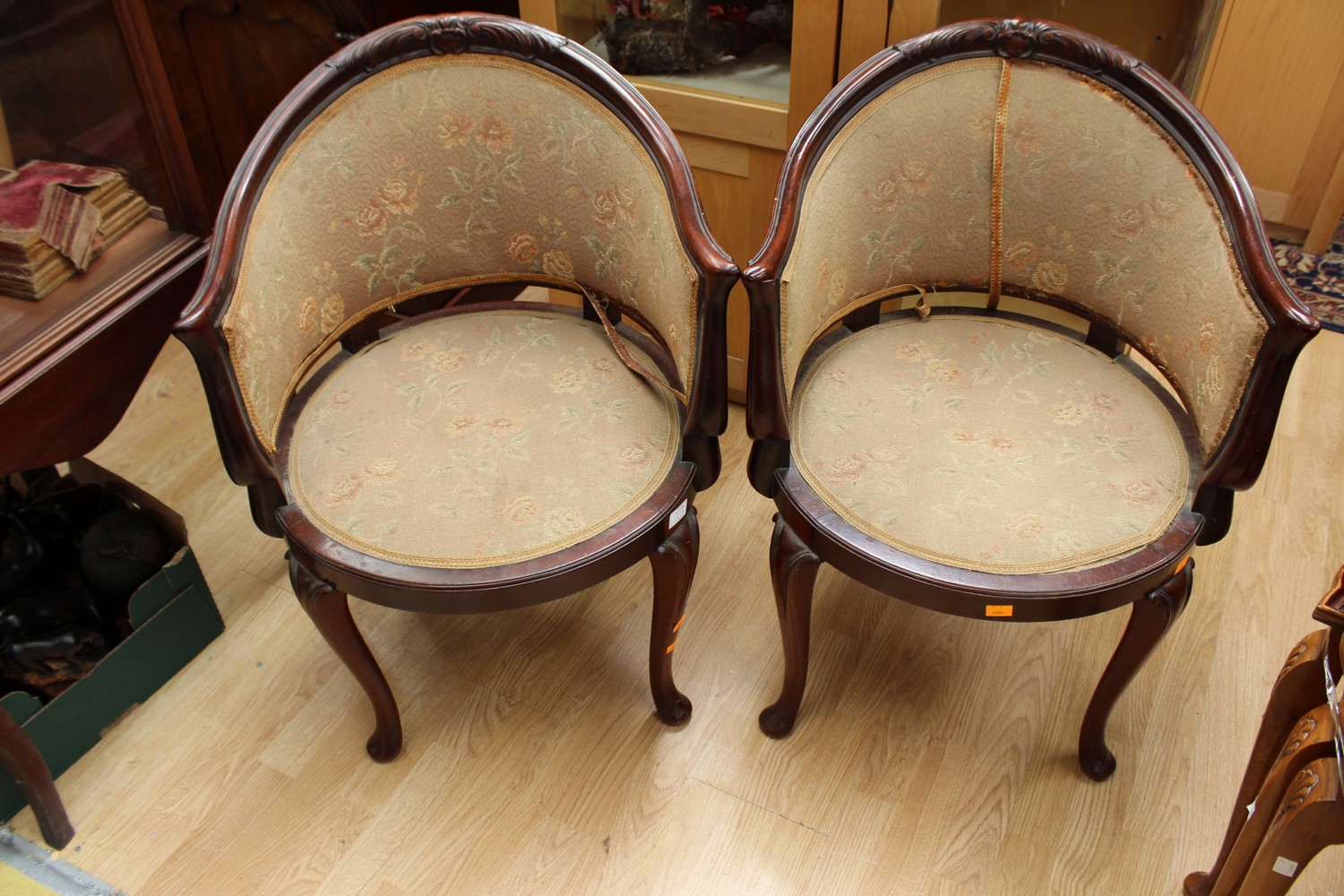 A pair of late Victorian mahogany tub chairs, with carved crest rails,