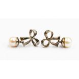 A pair of white metal and pearl drop earrings, fashioned as tied bows ,