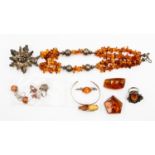 A collection of silver and amber jewellery, including brooches, rings, earrings,