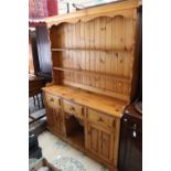 A traditional pine dresser, the rack with plate shelves, the base with three drawers over two doors,