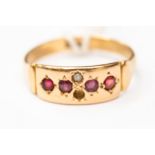 An 18ct gold circa 1910 ruby and seed pearl band, one pearl missing, size O,