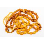 A collection of bead necklaces comprising a mix of plastic and re-constituted copal resin beads,