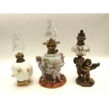 A ceramic oil lamp with three cherubs supporting reservoir;