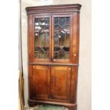 A large oak corner cupboard, double doors to base and glazed double doors to top,