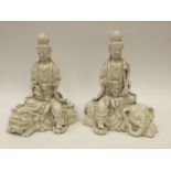 A pair of Chinese blanc de chine figures of Guanyin seated, one on a lion, the other on an elephant,