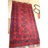 An Afghan tribal rug, red ground,
