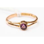 A 9ct rose gold and amethyst ring, set with an amethyst millgrain setting, size L,