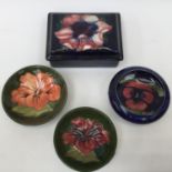 A Moorcroft trinket box and cover (seconds and repaired) with three further trinket bowls (one