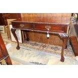 A George II style two drawer mahogany side table, gadroon carved top and apron,