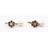 A pair of ruby and pearl drop earrings, rubies set in a flower setting, with a pearl centre,