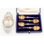 A silver tea strainer and set of four silver spoons (2)