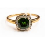 A tourmaline and diamond ring, comprising a cushion shaped stone, with a diamond surround,