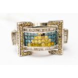 A large blue, yellow and white diamond dress ring, set in 14ct white gold, in the style of a buckle,