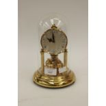 A Kern perpetual motion anniversary clock with glass dome, brass construction working order,
