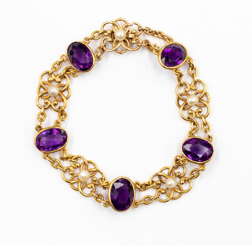An amethyst and pearl bracelet with fancy gold open flower links set to the centre with small