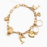 A 9ct gold charm bracelet with eight charms including a clam shell,