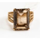A smoky quartz and 9ct gold dress ring, rectangular cut stone with heavily patterned shoulders,